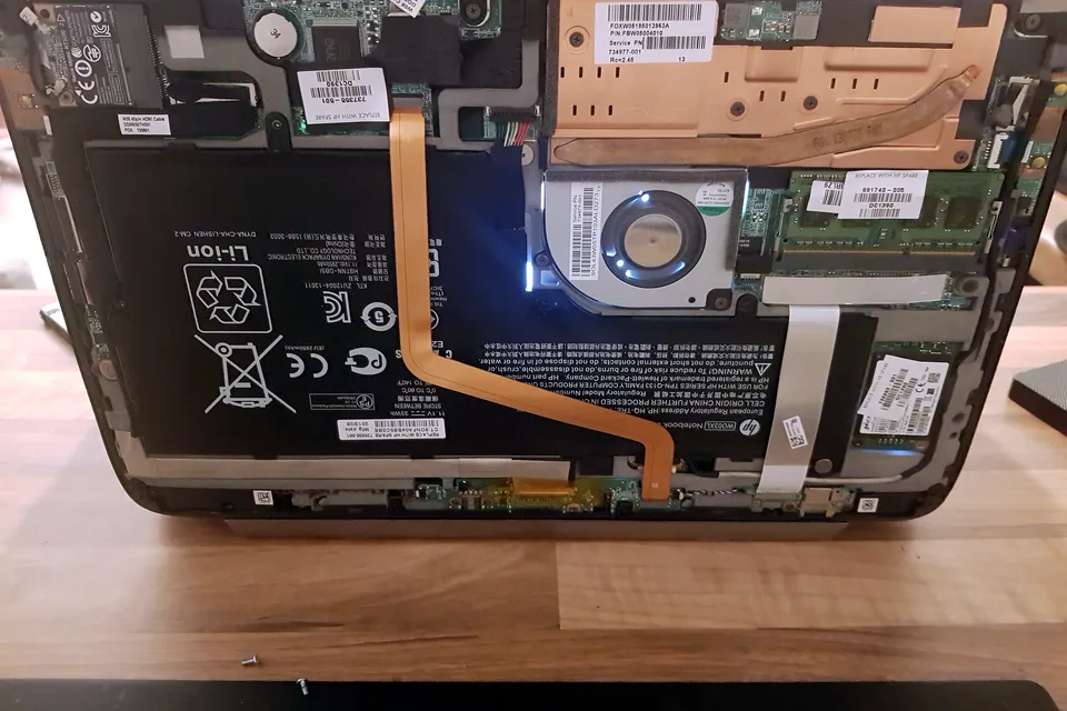 Laptop motherboard, battery and cooling system exposed for diagnosis